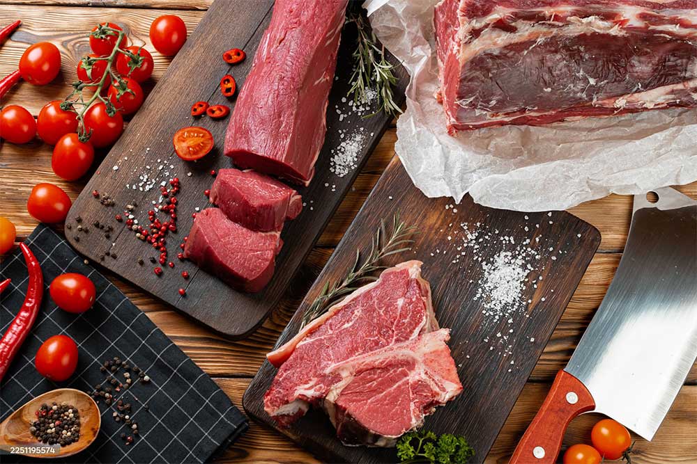 Slices raw meat fillet on wooden board, close up
